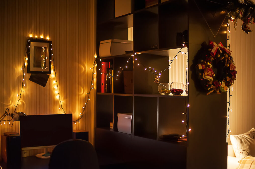 christmas interior decorations. garlands on the wall, wreath and christmas lights