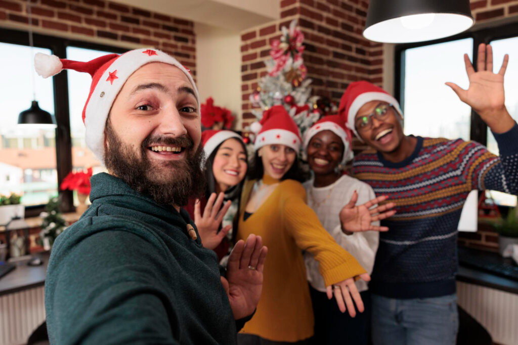 diverse group of people taking pictures with christmas tree, celebrating festive season with holiday