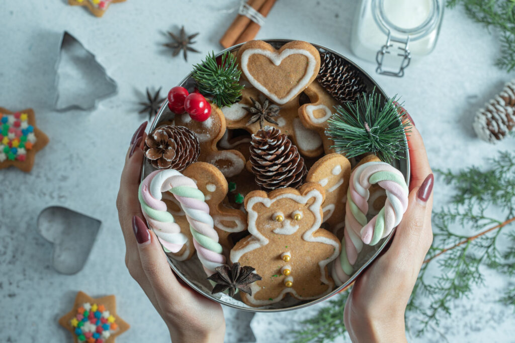 female-holding-crockery-hand-crockery-full-christmas-cookies-decorations