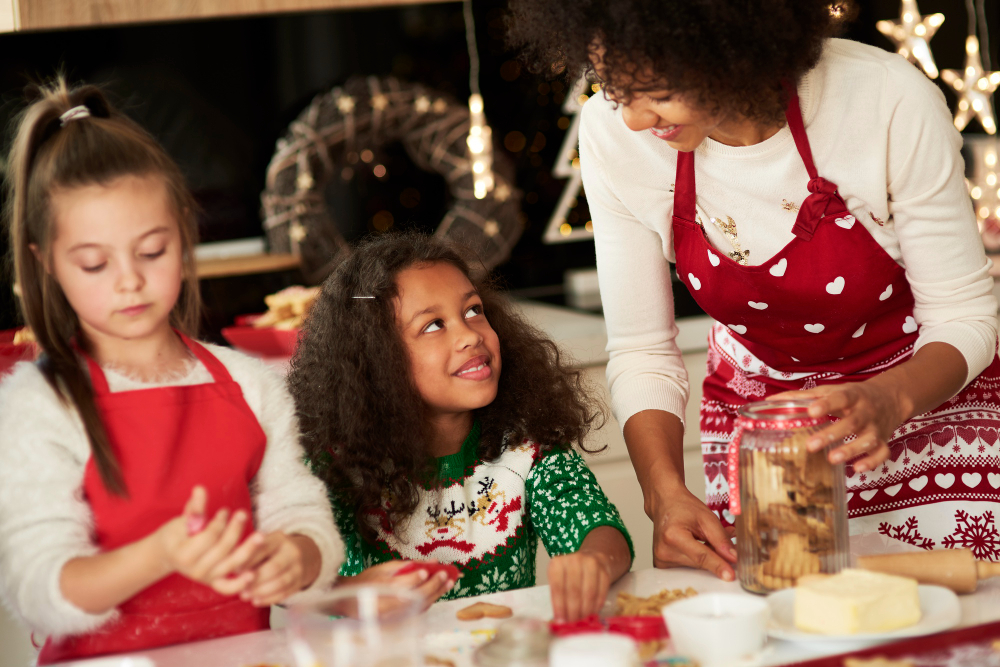 girls helping mom making cookies for christmas