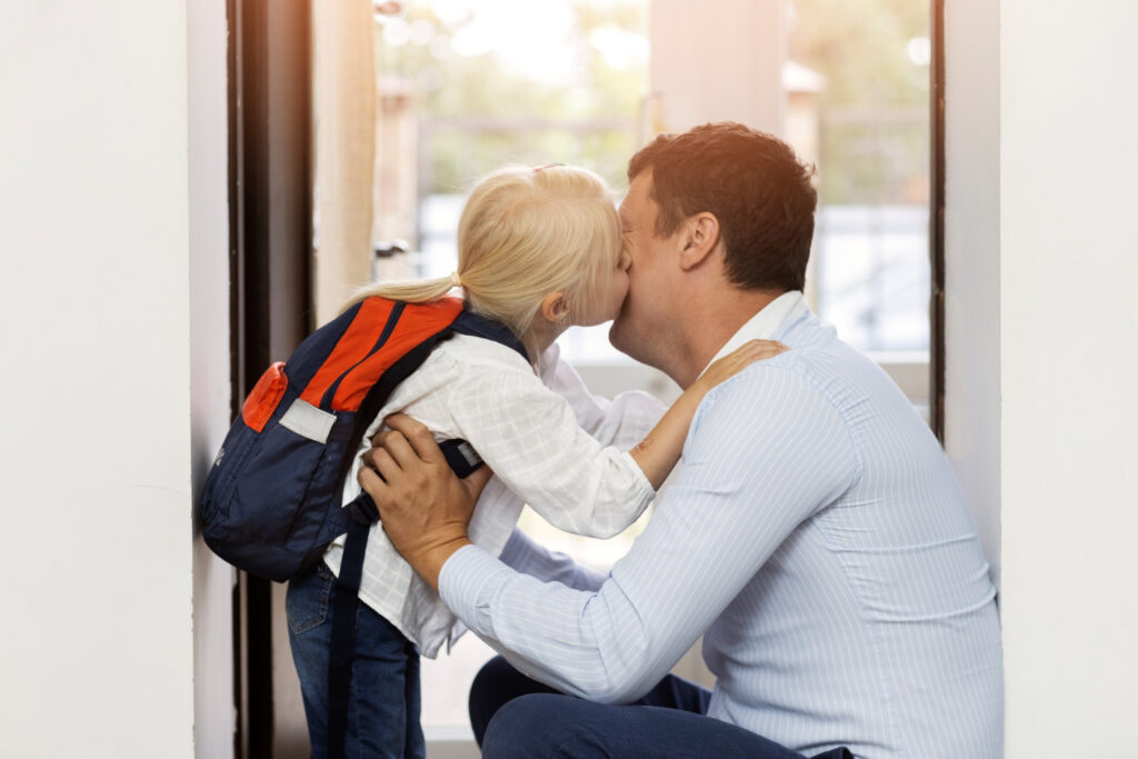 Side view girl kissing father on cheek