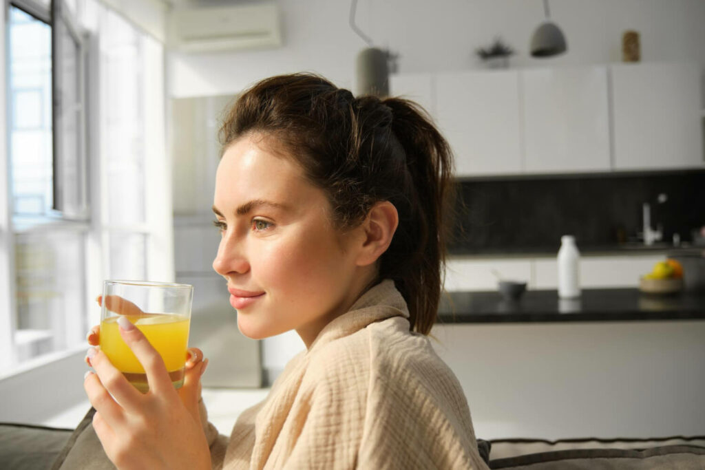 a woman holding a cup of lemon ginger tea