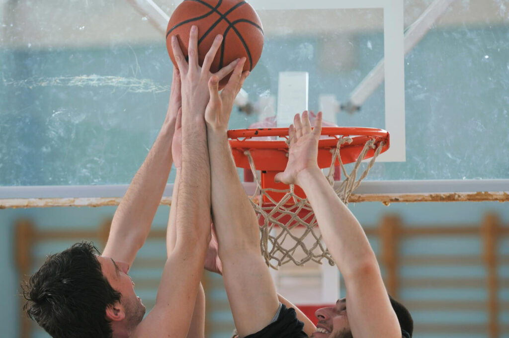 a basketball being thrown by hs kids